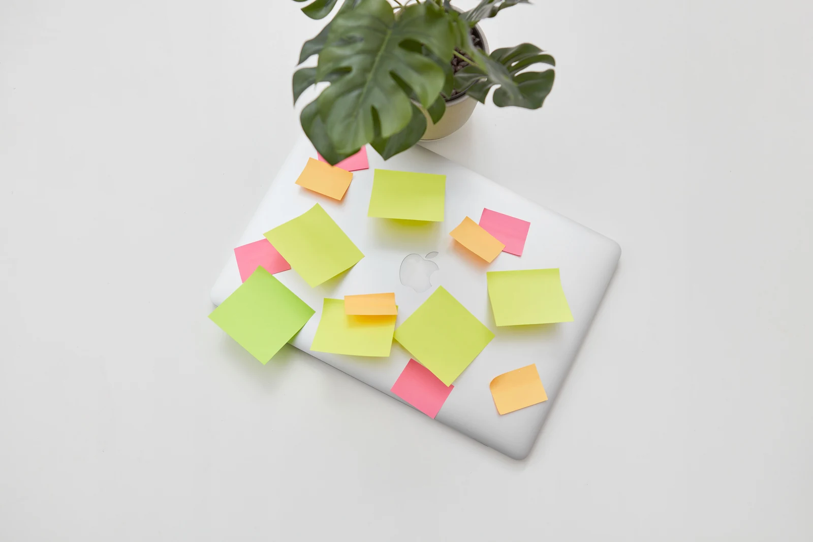 Laptop covered in brightly coloured sticky note reminders, a common way of managing ADHD symptoms at work