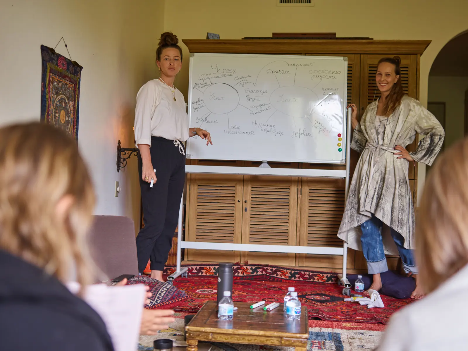 Two women leading a group confidence coaching session at a table
