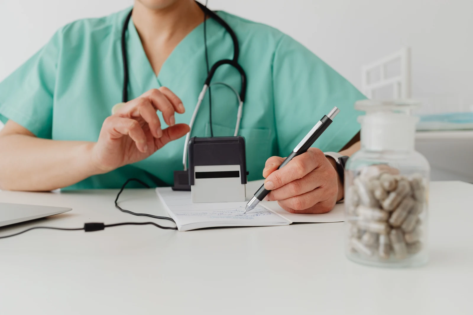 Medical professional writing notes at a desk during a consultation about perimenopause fatigue