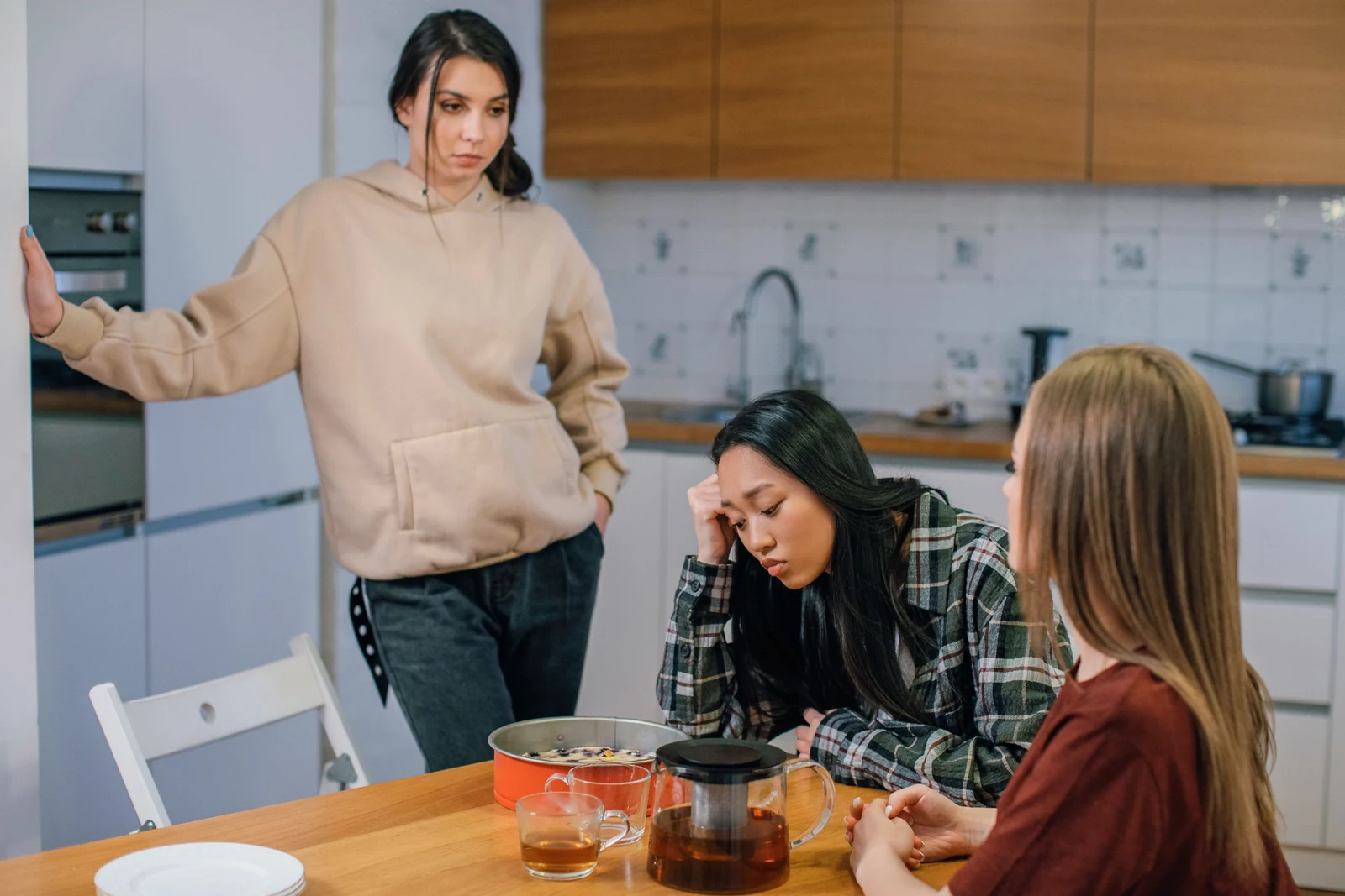 Women in a kitchen offering support to a friend during a difficult moment